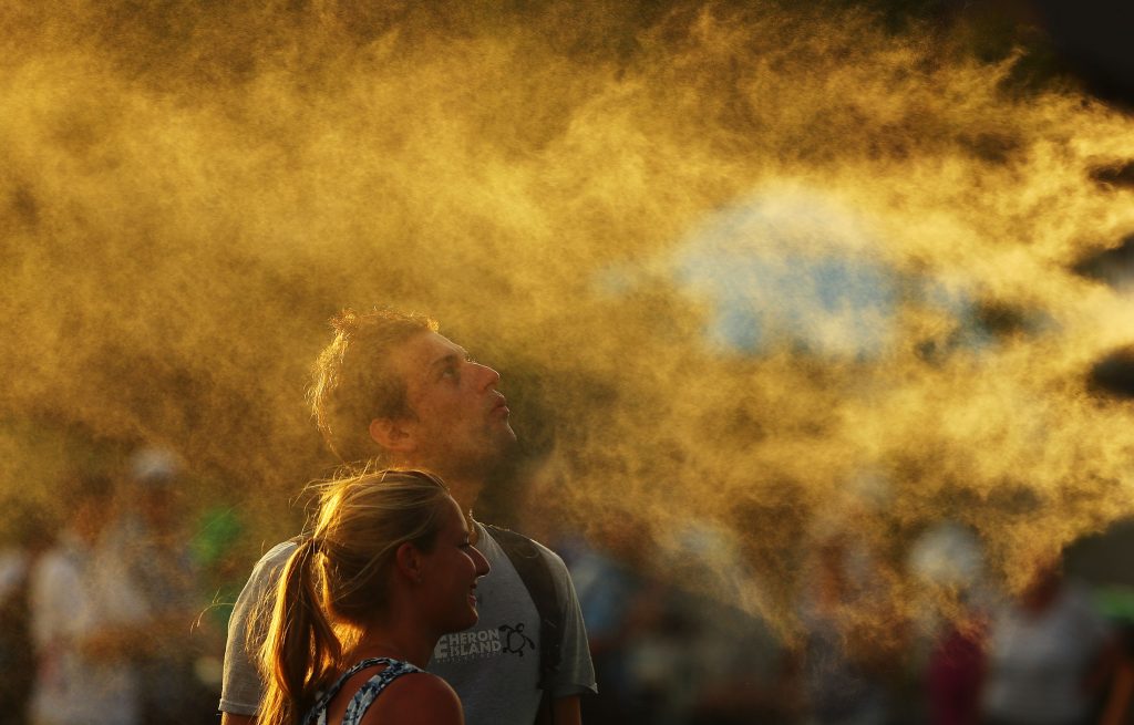MELBOURNE, AUSTRALIA - JANUARY 16: Tennis fans cool off from the heat in front of mist cooling fans on day one of the 2017 Australian Open at Melbourne Park on January 16, 2017 in Melbourne, Australia. (Photo by Scott Barbour/Getty Images)