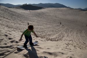 Children play on the dunes of Joaquina in Florianopolis, Brazil (Photo by Paulo Fridman/Corbis via Getty Images)