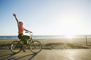 Caucasian woman riding bicycle near beach