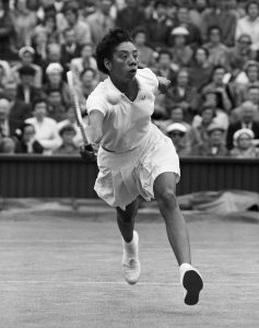 Tennis player Althea Gibson hits the ball during a match at the 1956 Wimbledon Championships. (Photo by © Hulton-Deutsch Collection/CORBIS/Corbis via Getty Images)